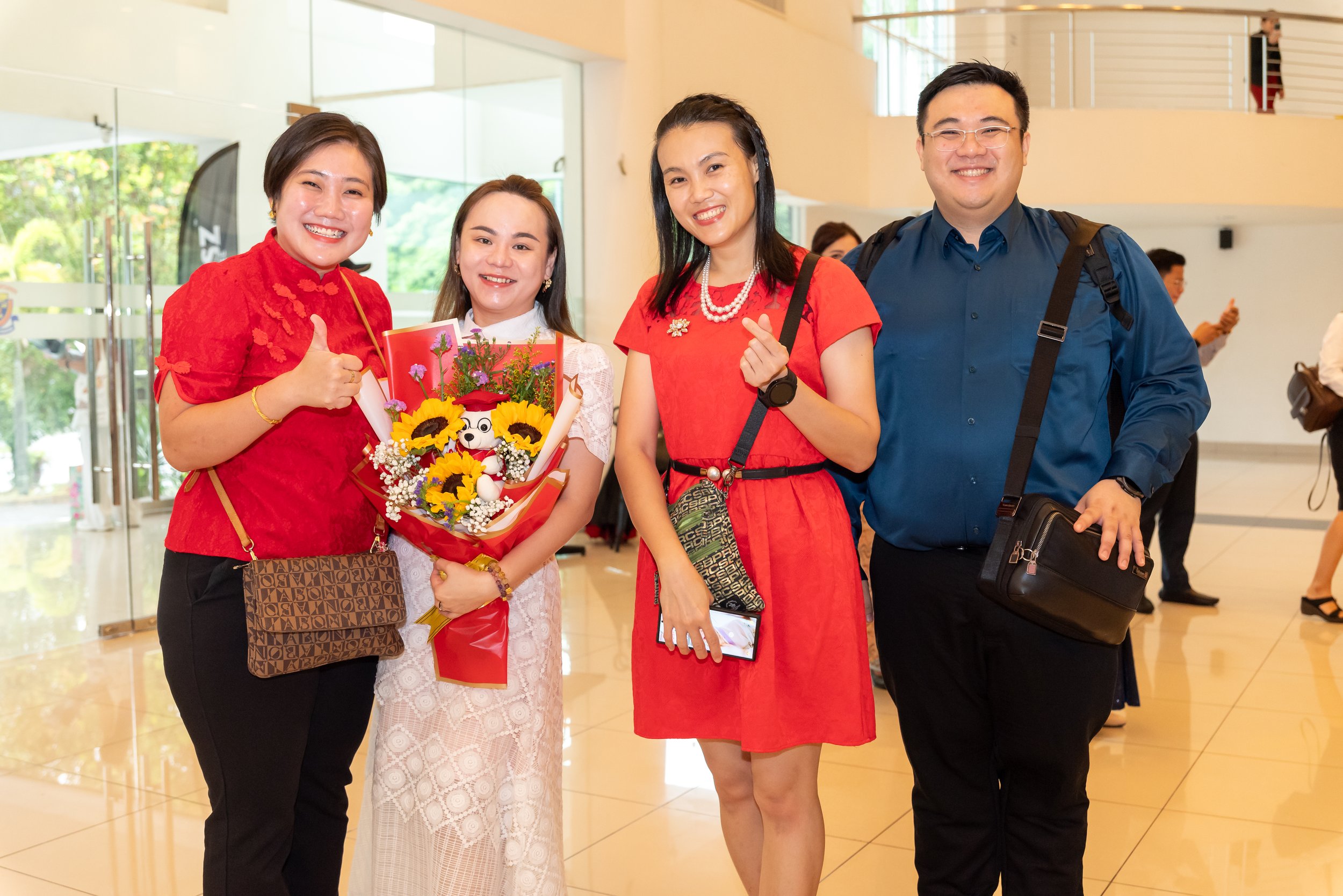 Graduate with family and flowers